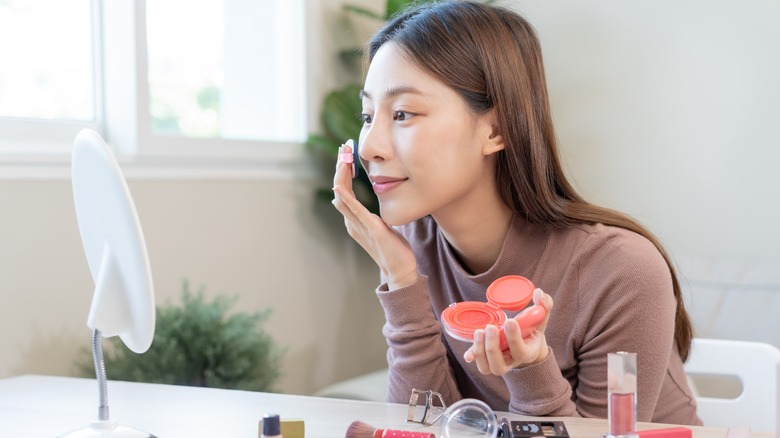 A woman applying blush