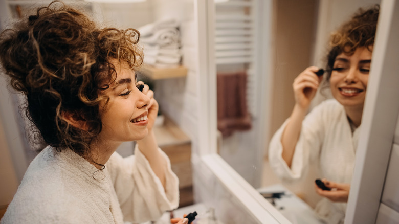 A woman applying mascara