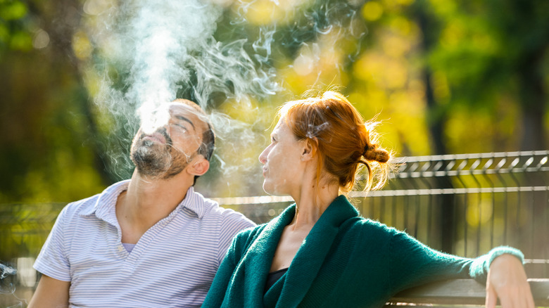 sad couple with man smoking