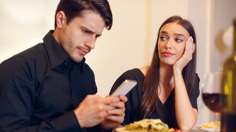 unhappy couple with man on phone