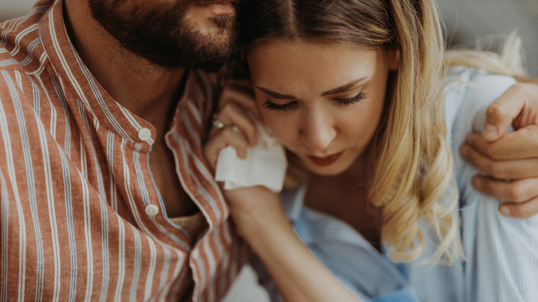 man hugging upset woman