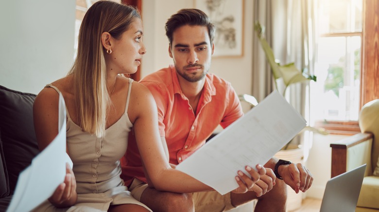 Frustrated couple holding paperwork