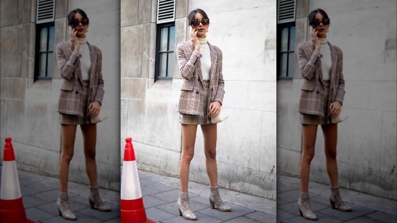 Woman wearing short plaid skirt suit