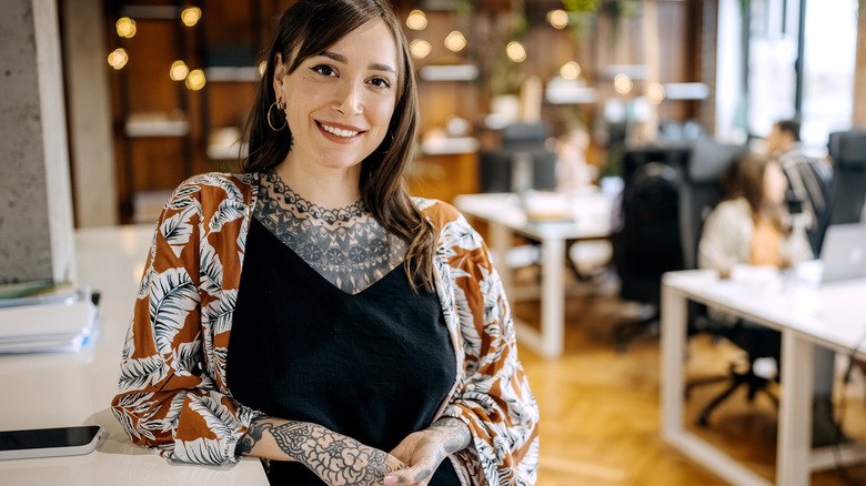 Smiling woman with chest and arm tattoos