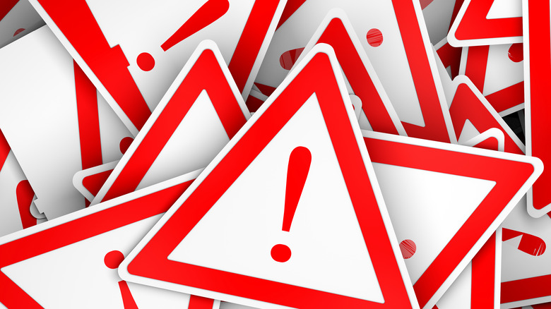 Messy pile of triangular warning signs with exclamation points