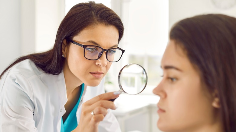 Woman getting mole checked by doctor