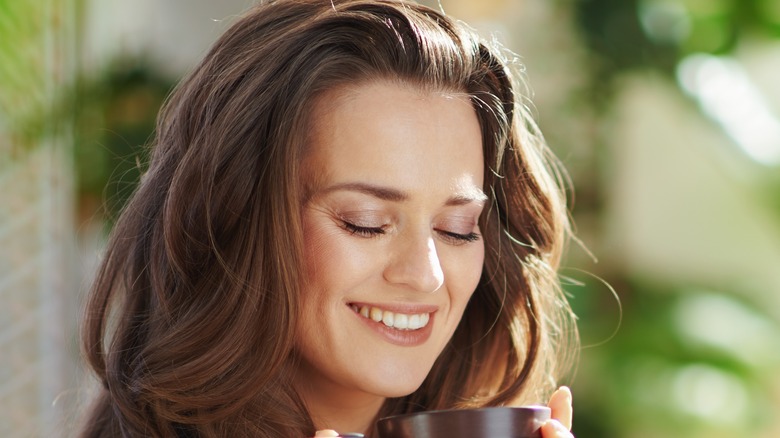 female neat styled hair drinking coffee