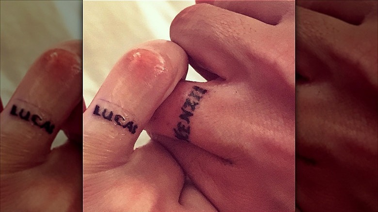 couple wearing wedding ring tattoos