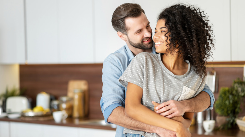 man embracing woman in kitchen