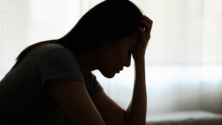 Person sitting in dark feeling sad