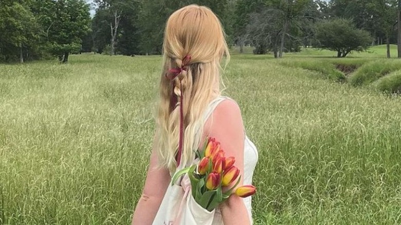 woman walking in field with tulips