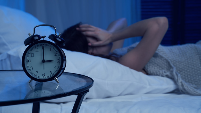 Woman with insomnia dark bedroom