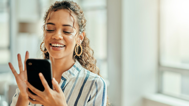 Woman smiling while using phone