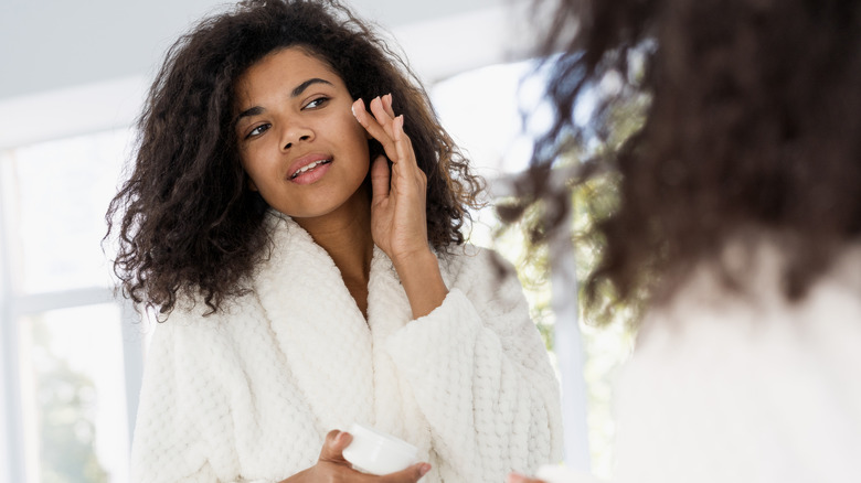 African American woman putting on face cream