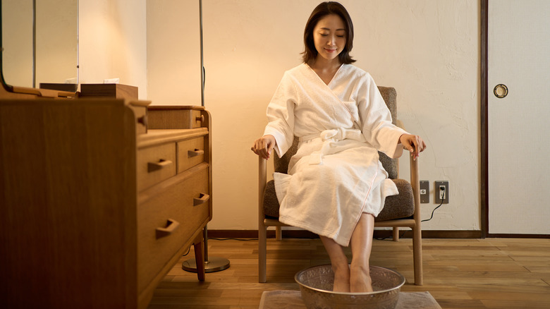 woman soaking feet in bath