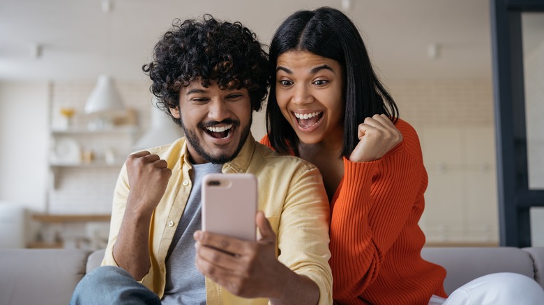 couple raising fists cheering