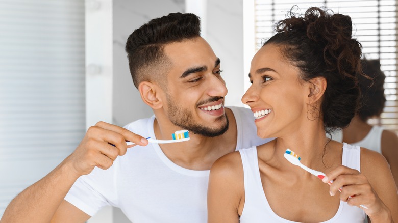 couple brushing teeth together