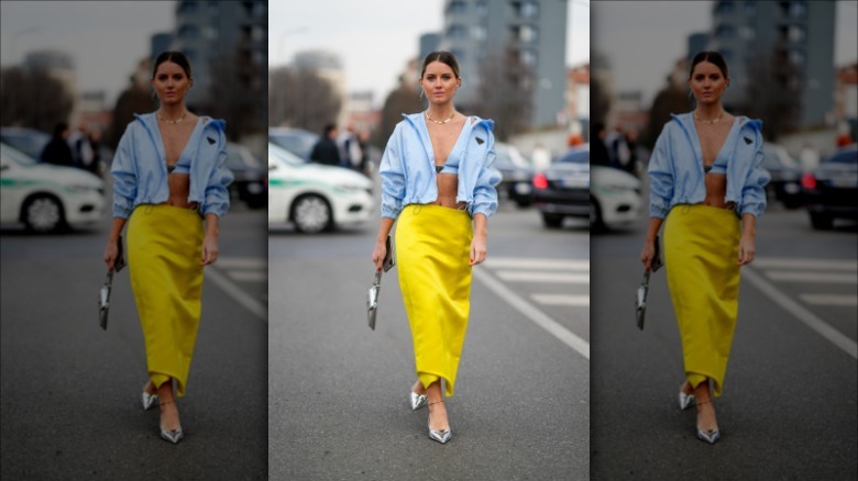 woman with a blue top and jacket and yellow slip skirt