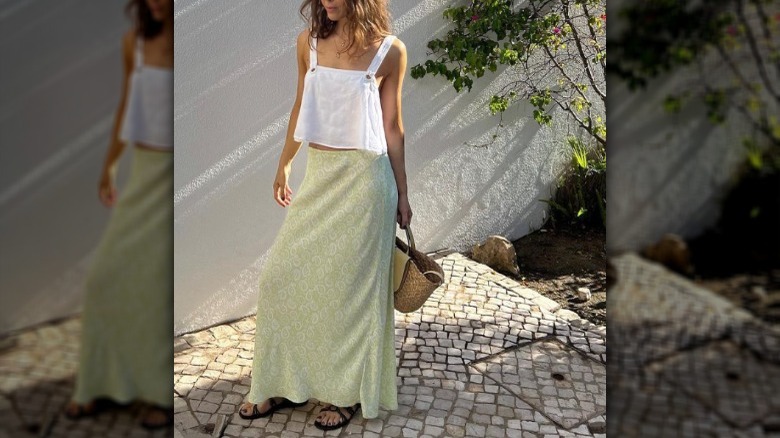 woman with a white linen top and green maxi slip skirt