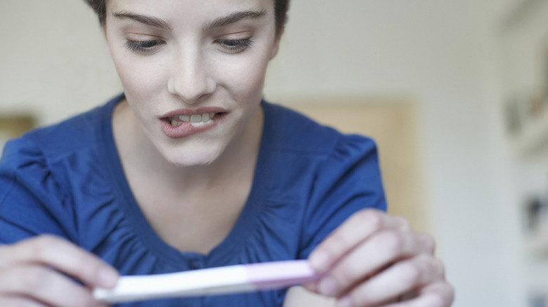 woman looking at pregnancy test