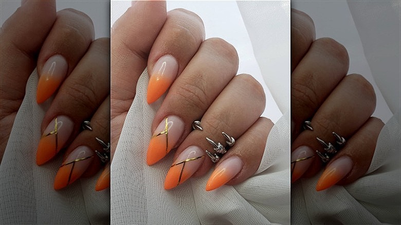 woman with creamsicle and gold nails