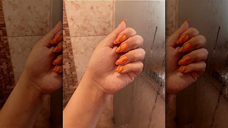 woman with 70's swirly orange creamsicle nails