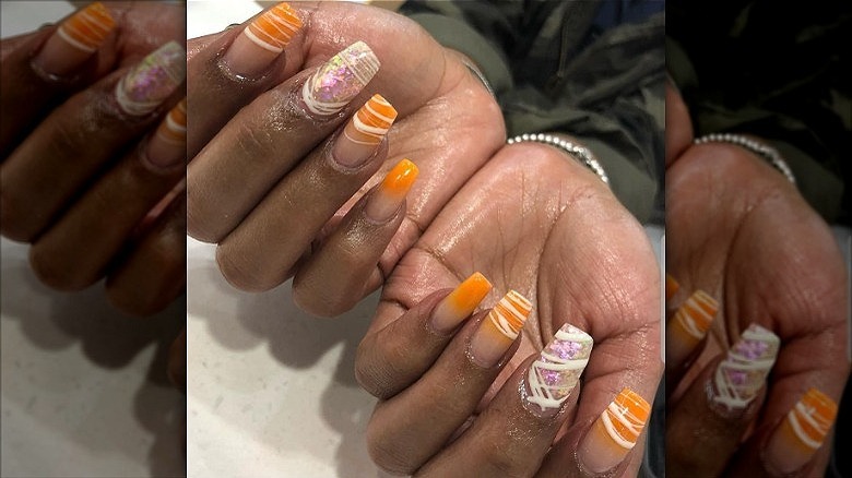 woman with orange creamsicle nails