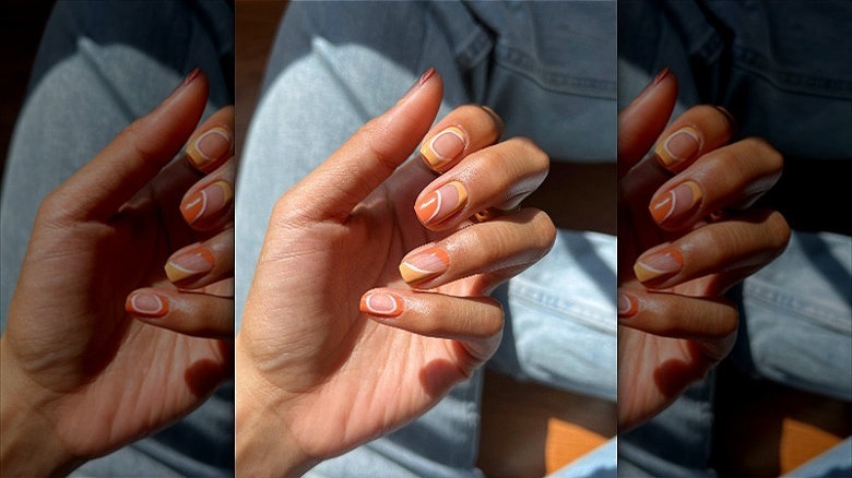 woman with orange creamsicle nails