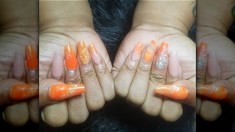 woman with sparkly orange creamsicle nails