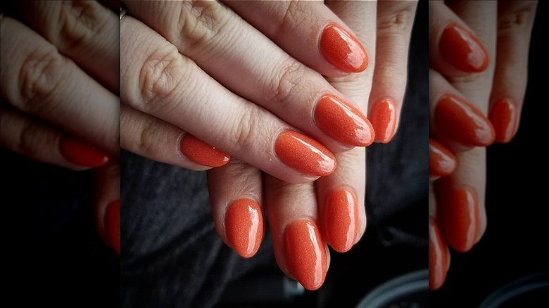 woman with shimmery orange creamsicle nails