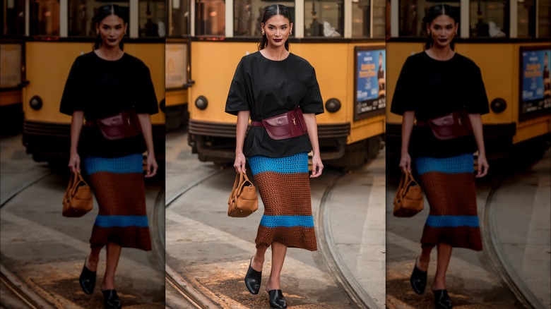 A woman wearing a brown and blue midi crochet skirt