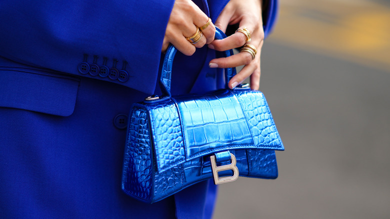 woman holding a crocodile bag