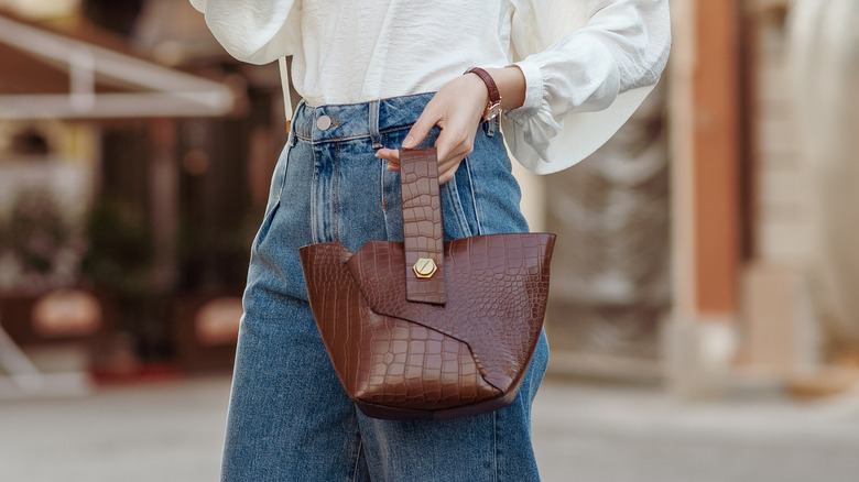 woman holding a crocodile bag