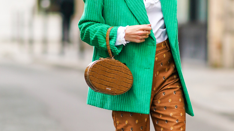 woman holding a crocodile bag