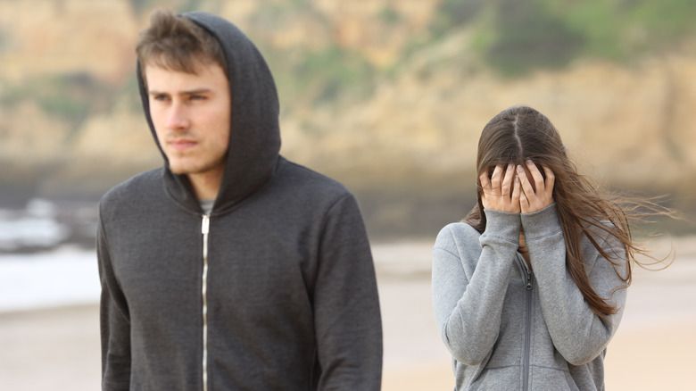 Man walking away from woman as she cries 