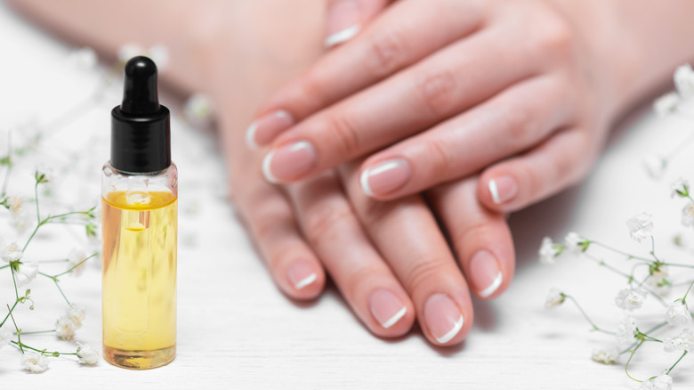 bottle and hands with French manicure