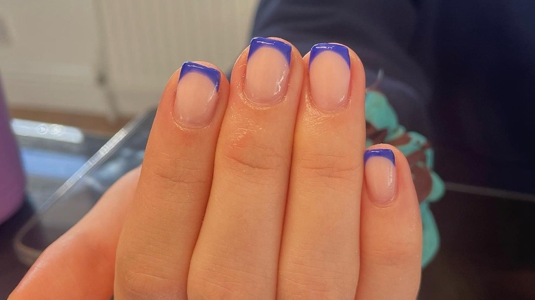 Hand with blue French manicure