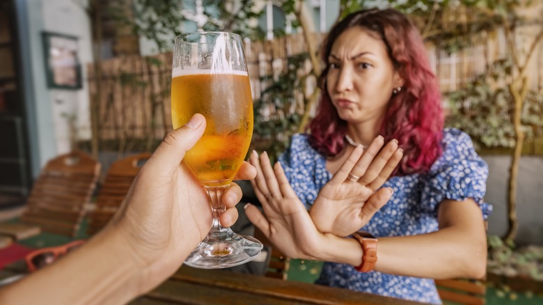 woman refusing beer