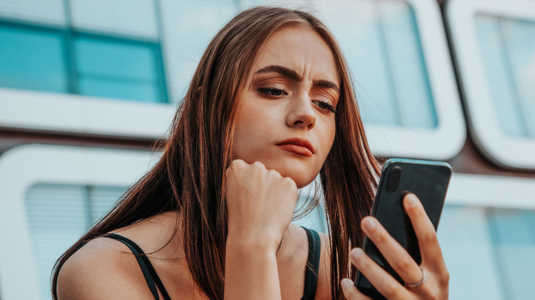 woman looking at phone concerned