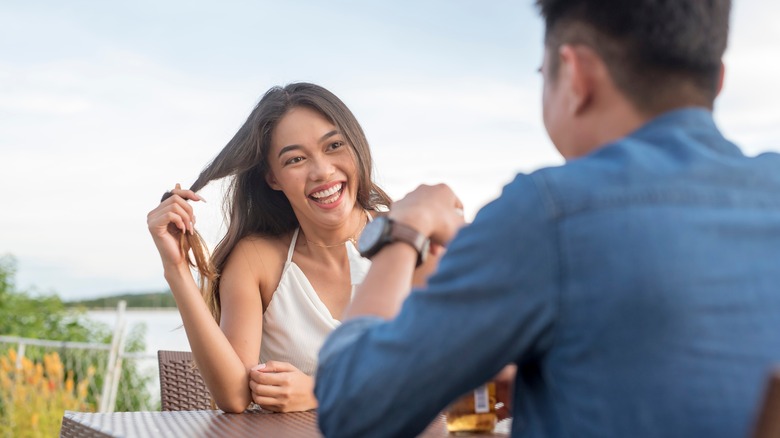 Woman smiling and twirling hair