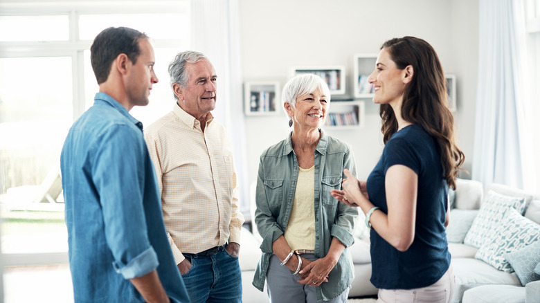 Couple standing in living room with parents