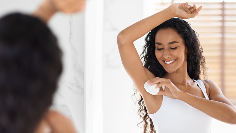 woman applying deodorant