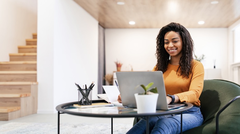 Woman smiling and working on laptop