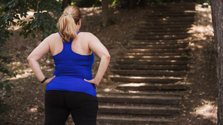 Woman pauses before running up staircase