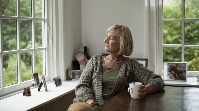 Woman looking out window with tea