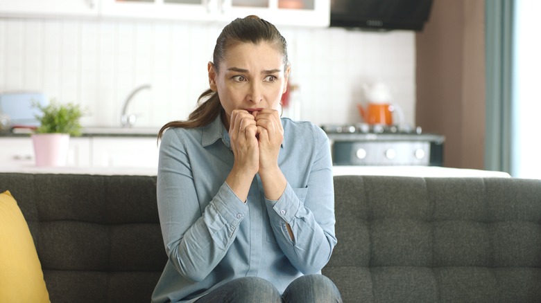 Woman biting nails in worry