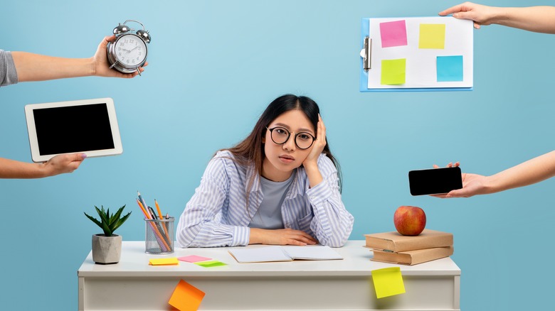 Woman surrounded by alarm, computer, other tasks