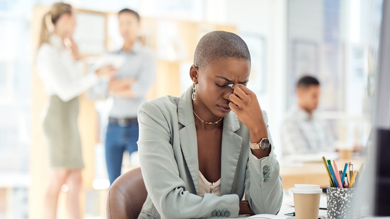 Woman pinching nose in anxiety