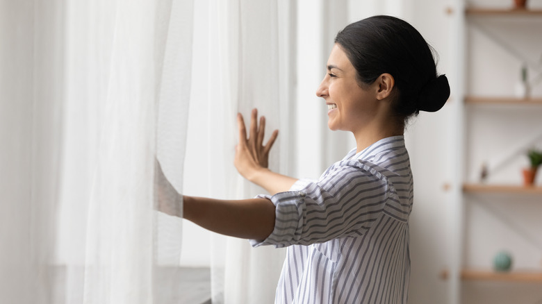 Woman looking out window, smiling