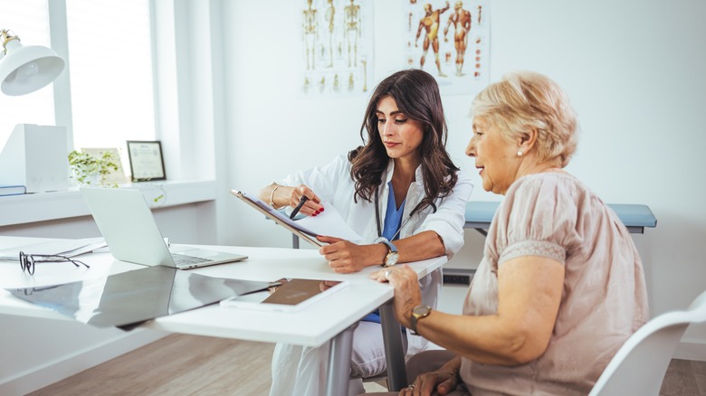 Woman discusses with physician 